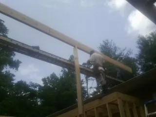 Carpenter setting a ridge beam over a new addition frame — Ice Dam Removal by Roofing Brothers in Oak Park